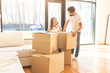 © xartproduction - young couple moves to a new home. the family carries boxes of things after buying a home.