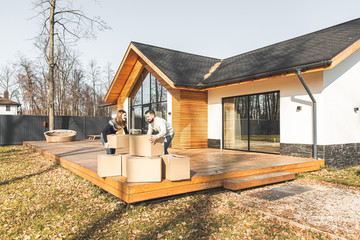 Wall Mural - young couple moves to a new home. the family carries boxes of things after buying a home.