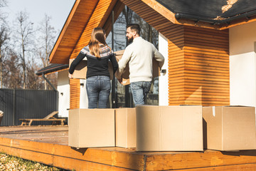 Wall Mural - young couple moves to a new home. the family carries boxes of things after buying a home.