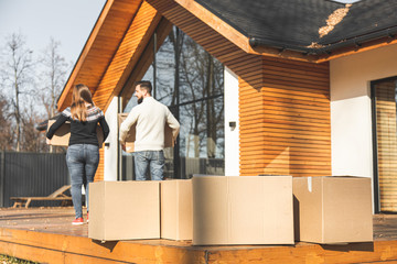 Wall Mural - young couple moves to a new home. the family carries boxes of things after buying a home.