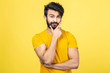 © xartproduction - Emotional portrait of a Hindu man in a yellow T-shirt on a bright orange background