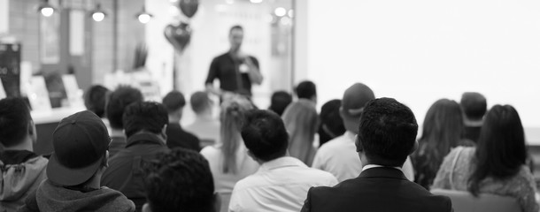 Fototapete - Conference photo audience and speaker giving speech. Seminar presenter on a panel during forum. Corporate manager in sales executive training discussion on stage. Investor pitch presentation.