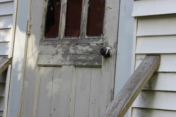 Wall Mural - Old abandoned weathered boarded up historic country farmhouse with boarded up windows and peeling paint