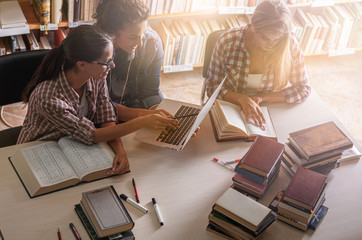 Wall Mural - Group of female students study in the college library in the morning.Learning and preparing for exam.Educational concept.	