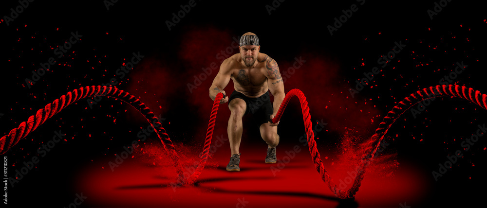 Man working out with battle ropes - obrazy, fototapety, plakaty 