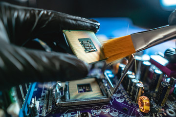 Wall Mural - Engineer repairman holding hands CPU to insert into the socket of the motherboard. Technology hardware in the neon light