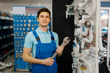 Wall Mural - Plumber with pipe wrenches poses at the showcase