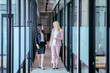 © Creativa Images - Women chatting while walking down the hallway