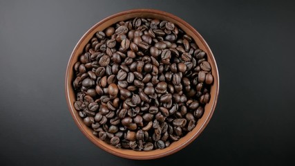 Wall Mural - coffee beans on brown plate in black background