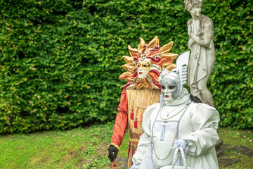 Couple standing in masks and masquerade costumes during Venetian carnival in Annevoie  gardens, Rue des jardins, 37 a, Annevoie/ Belgium