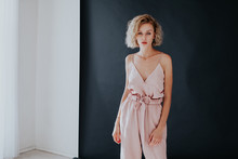 Portrait Of A Beautiful Fashionable Blonde Woman In A Pink Jumpsuit On A Black White Background