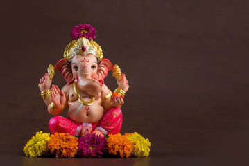 Hindu God Ganesha. Ganesha Idol on dark wooden background.