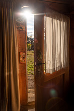 An Open Door With Sun Rays Passing Through, Seen From The Interior Of A Wooden Cozy And Relaxing Cabin That Leads To The Forest And Lake. Concept Of Relaxation, Vacation, Freedom And Home.