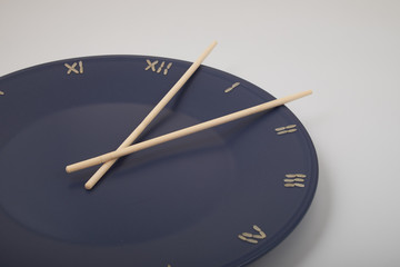 Wall Mural - clock, time concept with rice on a blue plate, top view