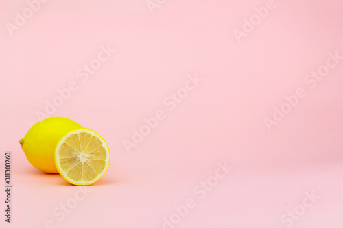 Yellow lemon and part of it on a pink background with place for text Poster Mural XXL