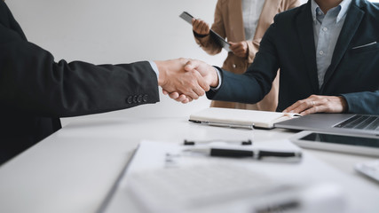 Business executives shaking hands after meeting at office, colleagues management