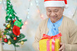 © amazing studio - Asian senior or elderly old lady woman patient with Santa Claus helper hat holding gift box in christmas and new year celebration festival holiday party in hospital. .