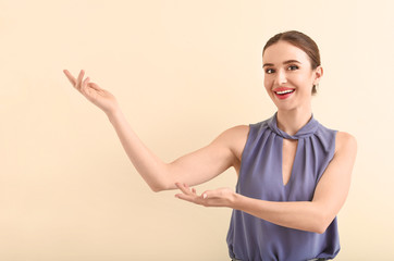 Wall Mural - Female real estate agent showing something on light background