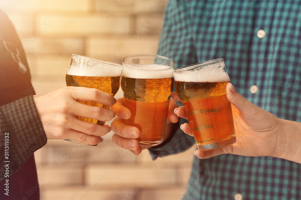 People clinking glasses of beer indoors