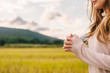 © thatinchan - A young woman shows the symbol of prayer to God for the blessings of the Lord to find good things with faith in the sacredness and power of God on the blurred background of nature in the morning.