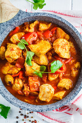 Wall Mural - Jalfrezi chicken in fried pan with a bowl of rice, top view. Traditional indian cuisine concept.