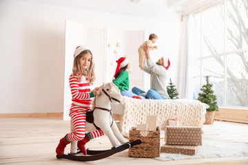 Wall Mural - Little girl with family resting at home on Christmas eve