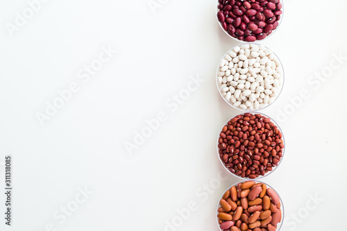 Cuadros en Lienzo Different seed beans in round plates are arranged in a row.