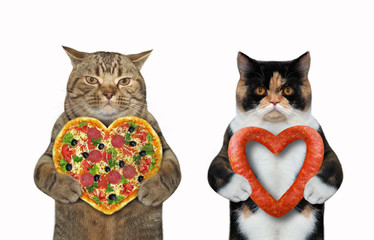 Wall Mural - There are two cats. The first is holding a heart shaped pizza and the second sausage. White background. Isolated.