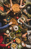 Fototapeta Uliczki - Traditional Turkish family celebration dinner. Flat-lay of people feasting at table with Turkish salads, cooked vegetables, meze starters, borek pie and raki drink, top view. Middle Eastern cuisine