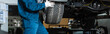 © LIGHTFIELD STUDIOS - cropped view of mechanic installing wheel on car in workshop, panoramic shot