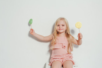 little girl eating sweet candy lollipop on a stick