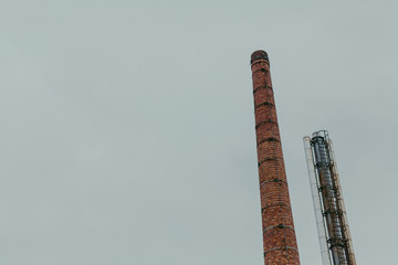 Two tall industrial chimney against sky