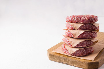 raw frozen minced meat patties on a white background. There is a place for text