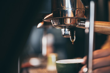 Close-up of espresso pouring from coffee machine. Professional coffee brewing