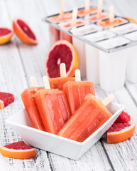 Wall Mural - Old wooden table with freshly made Grapefruit Popsicles