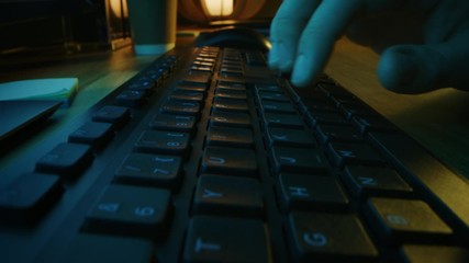 Close-up Moving Macro Shot: Person uses Mouse, Typing on the Computer Keyboard. Working, Writing Emails, Using Internet. Green and Blue Colors in the Evening