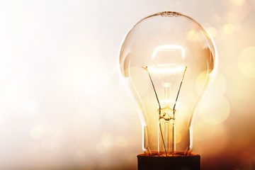 Poster - Glowing glass light bulb on background