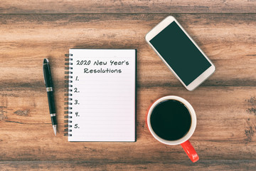 Wall Mural - New year Concept - 2020 number and text on notepad. Smartphone, pen and cup of coffee background.