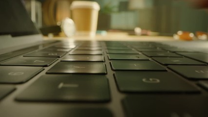 Close-up Moving Macro Shot: Person Typing on Laptop Keyboard finishing with Pressing Enter Button. Working, Writing Emails, Using Internet. Notebook lying on the Tablet, Bright Sunny day in Background