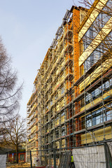 Wall Mural - scaffolding arround the house to install thermal insulation of the apartment building facade