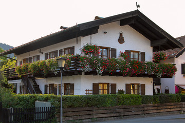 Wall Mural - OBERAMMERGAU, GERMANY - September 25, 2011: Bavarian rural house with a balcony decorated with flowers in Oberammergau.