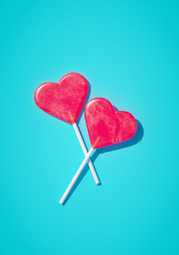 Minimalist love Valentine day couple heart shape concept, romantic wedding idea. two Heart red lollipops on blue background. 3d rendering.