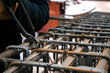 Rebar at a construction site. Attaching the rebars to each other. Worker's hands fasten the reinforcement with wire.