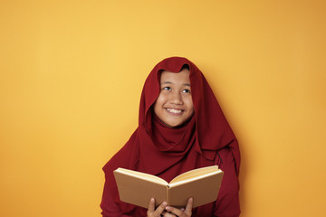 Wall Mural - Muslim Teenage Girl Reading Book and Thinking, Happy Smiling Expression