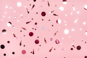 Poster - Falling foil confetti with bottle of champagne and circles on pink background. Party concept