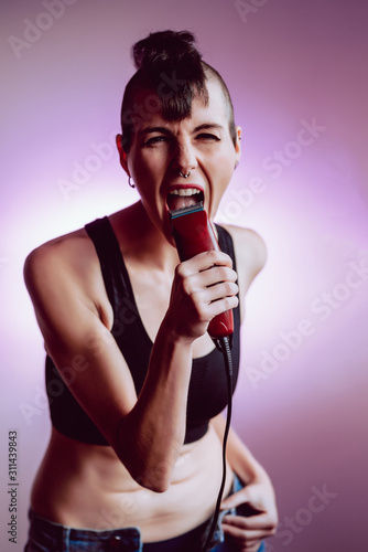 Fotografía Young and attractive girl with shaved hair and punk style sings