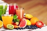 Composition of fruits and glasses of juice on blurred natural background
