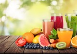Composition of fruits and glasses of juice on blurred natural background