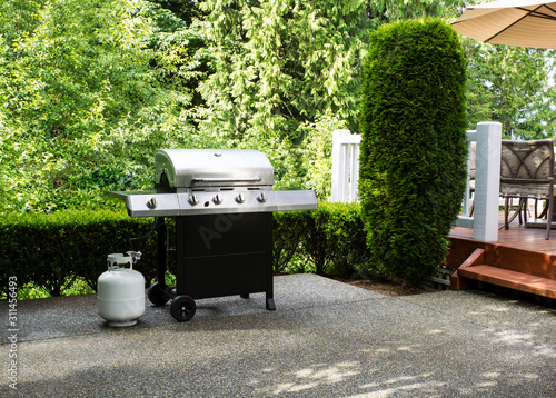 Cuadros en Lienzo Outdoor cooker on House concrete patio with home deck on side