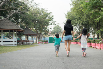 Asian Mother and daughter walking together in a warm embrace. Represents a good rapport within the family, happy family time.